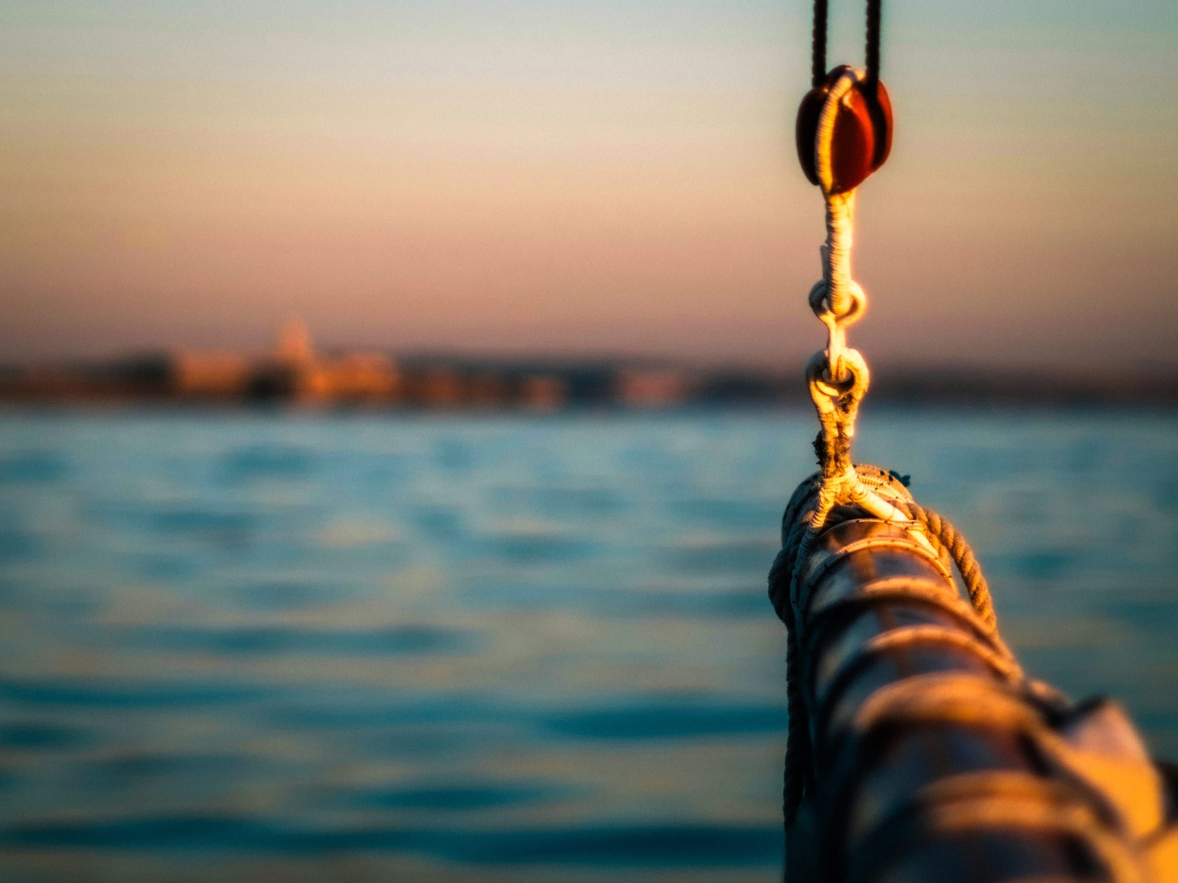 Editorial photograph — the bow of a sailboat on still water in soft bokeh