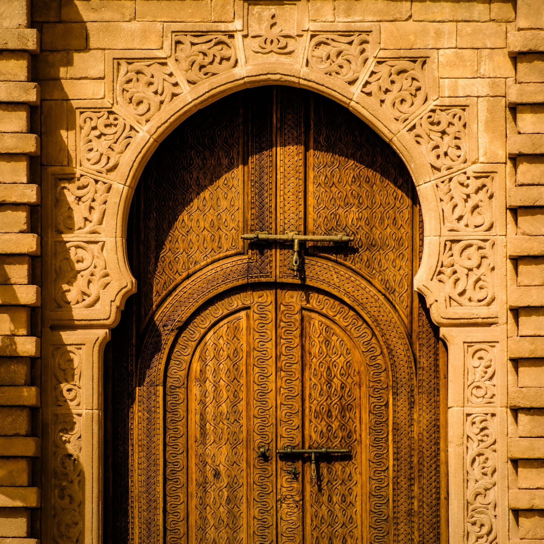 Editorial photograph — a Moroccan riad doorway with hand-painted tilework